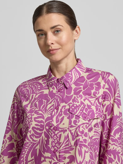 Frauenmodel trägt knielanges Hemdblusenkleid mit Brusttasche von WHITE LABEL in Lila mit floralem Allover-Muster, reine Baumwolle, Nahaufnahme Oberkörper.
