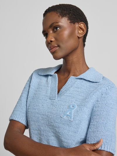 Frauenmodel trägt hellblauen Regular Fit Kurzarm-Pullover aus reiner Baumwolle Modell 'ICONIC' von ARMEDANGELS, Damen Pullover, Nahaufnahme Oberkörper.