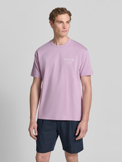 Męski model nosi Relaxed Fit T-Shirt aus reiner Baumwolle von Marc O'Polo, jednokolorowy, krój regular fit, nadruk z logo, okrągły dekolt, krótki rękaw, dżersej, bawełna, całkowity widok z przodu.