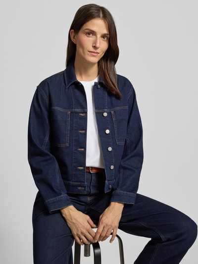 Frauenmodel trägt Regular Fit Jeansjacke mit Brusttaschen Modell 'Nusilia' von Someday in Dunkelblau, Umlegekragen, Baumwoll-Mix, Nahaufnahme Oberkörper.