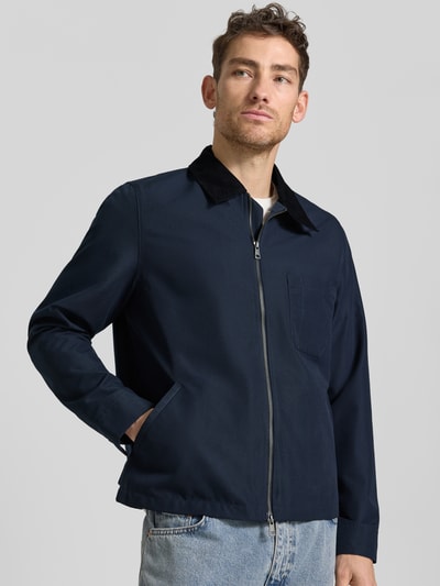 Männermodel trägt Jacke mit Kentkragen in Cord-Optik Modell 'ROBIN' von Samsøe Samsøe in Dunkelblau, Zweiwege-Reißverschluss, Seitliche Eingrifftaschen, gerade Formen, glatte Textur, Brusttasche, Ganzkörperansicht von vorne, Kontext: Herren Jacke, Gerader-Schnitt, Rückenlänge bei Größe M: 63 cm, Schulterbreite: 43 cm, Brustweite: 58 cm, Ärmellänge: 66 cm.
