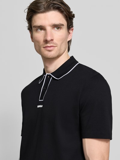 Männermodel trägt Regular Fit Poloshirt aus reiner Baumwolle Modell 'DALUMO' von HUGO, unifarben, Nahaufnahme Oberkörper.