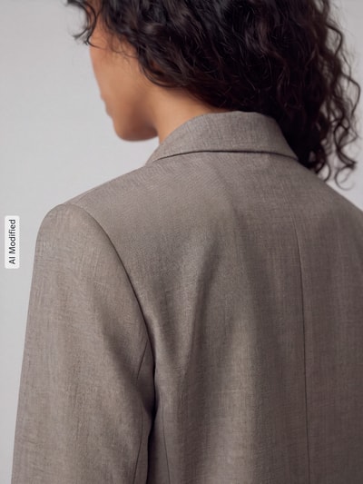 Vrouwenmodel draagt Relaxed Fit Longblazer met viscose, model 'RITA' van Selected in taupekleur, detailopname van de rug, KI-modified beeld.