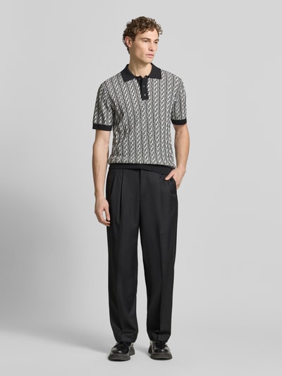 Mannenmodel draagt Regular Fit Poloshirt met polokraag model 'Tamian' van Drykorn, katoen, korte knoopsluiting, zwart-wit patroon, volledige lichaamsaanzicht van voren.