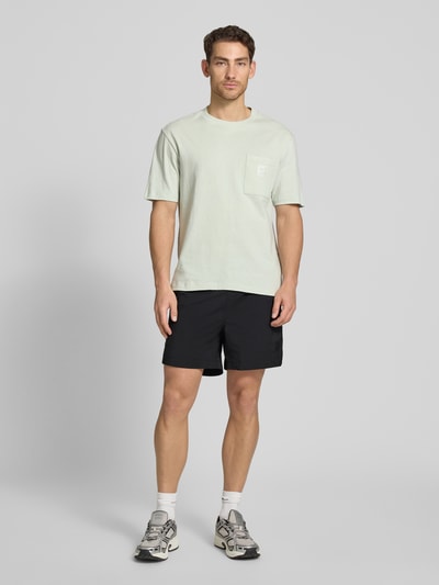 Männermodel trägt Regular Fit Shorts mit Label-Applikation Modell 'COLAS262S' von HUGO, Optik: Unifarben, Kontraststreifen, Bundabschluss: elastisch mit Tunnelzug, Eingrifftaschen, Ganzkörperansicht von vorne.