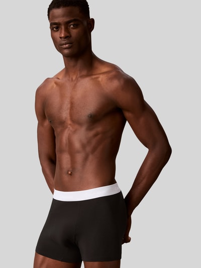 Männermodel trägt Regular Fit Trunks aus Baumwoll-Mix im 3er-Pack von Calvin Klein Underwear, mehrfarbig, Logo-Bund, Nahaufnahme Oberkörper.
