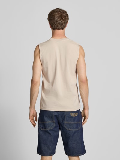 Männermodel trägt Tanktop mit Label-Stitching und Rundhalsausschnitt von Pegador, beige Farbe, reine Baumwolle, Relaxed Fit, Ganzkörperansicht Rückansicht