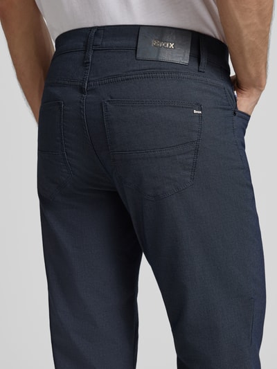 Mężczyzna nosi Regular Fit spodnie materiałowe z 5 kieszeniami model 'Cadiz' od Brax, mieszanka bawełny z dodatkiem streczu, widok z tyłu. Szerokość w pasie 43 cm, długość wewnętrzna nogawki 80 cm.
