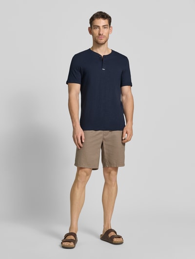 Männermodel trägt Regular Fit T-Shirt aus reiner Baumwolle von s.Oliver RED LABEL, Optik: Unifarben, Henley-Kragen, Kurzarm, Ganzkörperansicht von vorne.