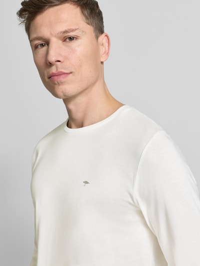 Männermodel trägt Longsleeve mit Rundhalsausschnitt und Logo von Fynch-Hatton, Unifarbenes-Design in Weiß, Reine Baumwolle, Regular-Fit, Nahaufnahme Oberkörper.
