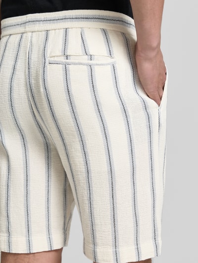 Männermodel trägt Regular Fit Shorts aus reiner Baumwolle Modell 'REGCAL' von SELECTED HOMME, gestreift, Nahaufnahme Rückansicht.