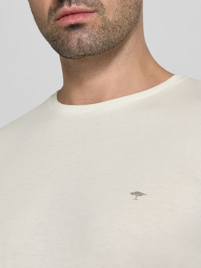 Męski model nosi T-Shirt mit Rundhalsausschnitt und Label-Stitching von Fynch-Hatton, bawełna, krój regular fit, okrągły dekolt, wyhaftowane logo, długość tyłu w rozmiarze M: 72 cm, jasny kolor, gładka faktura, zbliżenie na górną część torsu