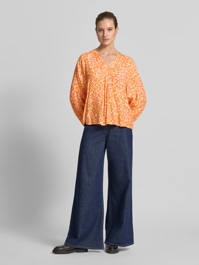 Frauenmodel trägt Damenbluse im Allover-Look mit V-Ausschnitt von Emily Van den Bergh in Orange, reine Viskose, Regular Fit, Ganzkörperansicht von vorne.
