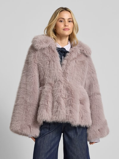 Modelka kobieca nosi Flared Jacke aus Kunstfell od ROTATE, kolor jasnoszary, prosta sylwetka, sztuczne futro, rękawy typu trąbka, podszewka z wiskozą, szerokość w rozmiarze 36: 39 cm, długość pleców: 60 cm, długość rękawa: 66 cm, widok całej sylwetki z przodu.