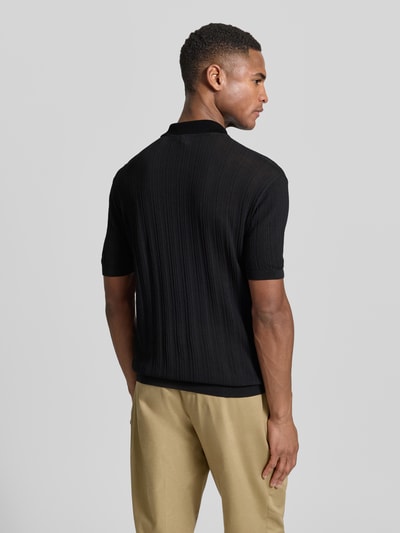 Männermodel trägt Body Fit Poloshirt mit kurzem Reißverschluss von Emporio Armani aus reiner Baumwolle in Schwarz; gerippte Abschlüsse, Rückenlänge bei Größe M 66 cm; Ganzkörperansicht Rückansicht.