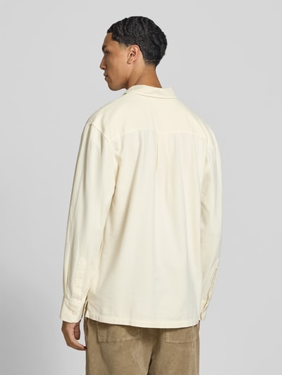 Männermodel trägt Regular Fit Poloshirt mit Brusttasche von Officine Générale, cremefarben, reine Baumwolle, langärmelig, Ganzkörperansicht Rückansicht