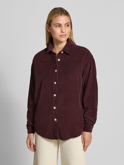 Frauenmodel trägt Oversized Hemdbluse aus reiner Baumwolle Modell 'Padow' von American Vintage in Cord-Optik, dunkles Rot, Ganzkörperansicht von vorne.