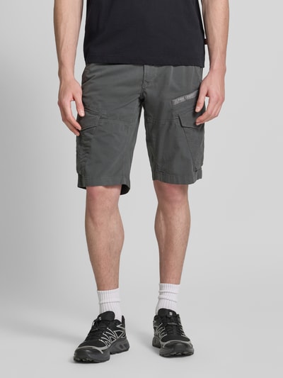 Mannenmodel draagt Tapered Fit Cargo Bermudas met pattentaschen model 'Nordrop' van PME Legend in katoenmix met stretch, steekzakken, klepzakken, strookzakken aan de achterkant, labelpatch, knoop- en ritssluiting, cargostijl, kleur grijs, effen textuur, ganzekörperansicht van voren.
