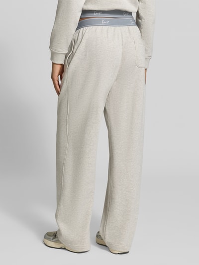 Frauenmodel trägt Wide Fit Sweatpants mit Logo-Stitching von Kenzo in heller Frottee-Optik aus reiner Baumwolle, elastischer Bund, Ganzkörperansicht Rückansicht.