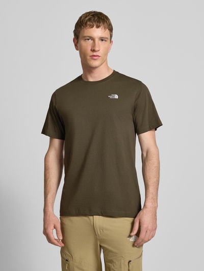 Männermodel trägt Regular Fit T-Shirt aus Baumwoll-Mix Modell 'EVOLUTION' von The North Face in Oliv, Rundhalsausschnitt, Label-Detail, Ganzkörperansicht von vorne.