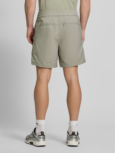 Männermodel trägt Regular Fit Shorts mit Label-Applikation Modell 'COLAS262S' von HUGO, Optik: Unifarben, Kontraststreifen, Eingrifftaschen, Bundabschluss elastisch mit Tunnelzug, Ganzkörperansicht Rückansicht.