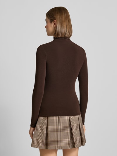 Frauenmodel trägt Regular Fit Langarmshirt mit Viskose-Anteil Modell 'GLAMOUR' von ONLY in Dunkelbraun, kombiniert mit kariertem Rock, Ganzkörperansicht Rückansicht, Damen Langarmshirt von ONLY.