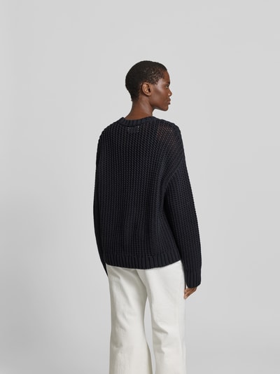 Frauenmodel trägt Pullover in Strick-Optik von Juvia, Baumwoll-Mix, Relaxed-Fit, semitransparent, Rückenlänge 67 cm, Ganzkörperansicht Rückansicht.