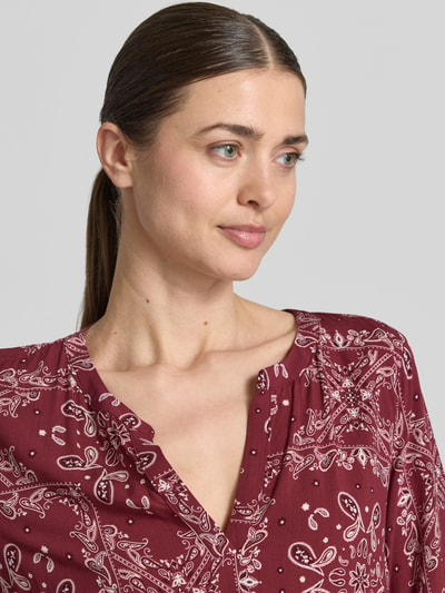 Frauenmodel trägt Relaxed Fit Minikleid aus reiner Viskose von Christian Berg Woman Selection mit Allover-Paisley-Print und Tunika-Ausschnitt in Rot, 3/4-Arm, Nahaufnahme Oberkörper.