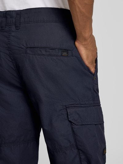 Männermodel trägt Capri-Bermudas mit Cargotaschen von camel active in Dunkelblau, reine Baumwolle, Regular Fit, Nahaufnahme Oberschenkel.