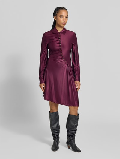 Frauenmodel trägt Knielanges Kleid aus Viskose-Mix von Rabanne in Burgunderrot mit Umlegekragen, Knopfleiste und Raffungen, taillierte Passform, langärmelig, glatte Textur, Ganzkörperansicht von vorne.