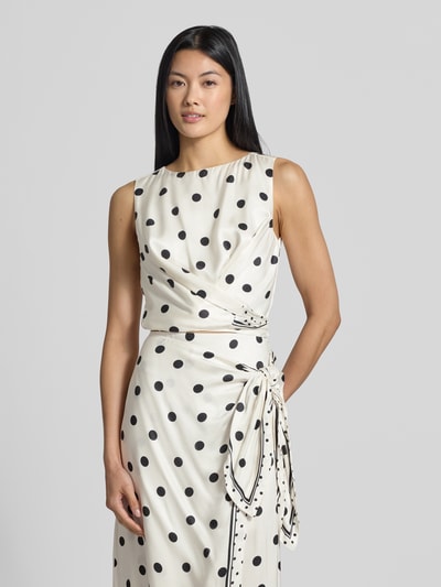 Vrouwenmodel draagt Regular fit blusentop uit zuiver viscose Model 'Veira' van Ted Baker, dames blusentop met mouwloos design en sierblouse, witte stof met zwarte stippen, gladde textuur, ruglengte bij maat 36: 41 cm, mouwlengte bij maat 36: 22 cm. Vooraanzicht bovenlichaam.