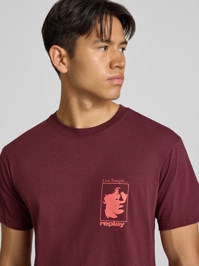 Männermodel trägt T-Shirt mit Motiv-Print und Rundhalsausschnitt von Replay in Bordeaux, reine Baumwolle, Regular Fit, Nahaufnahme Oberkörper.