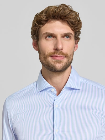 Männermodel trägt Slim Fit Businesshemd aus Baumwoll-Mix Modell 'HANK' von BOSS in Hellblau mit feinen Streifen, Nahaufnahme Oberkörper, Herren Businesshemd von BOSS.