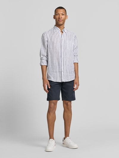 Männermodel trägt Bermudas mit Bindegürtel und französischen Eingrifftaschen von MAC, Baumwoll-Mix mit Stretch-Anteil, Ganzkörperansicht von vorne.