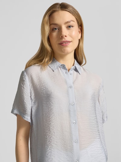 Frauenmodel trägt Relaxed Fit Bluse aus Modal-Mix mit Seiden-Anteil Modell 'MINA' von Samsøe Samsøe; hellgraue, halbtransparente Textur, Hemdblusenkragen, 1/2-Arm; Ganzkörperansicht von vorne. Rückenlänge 62 cm, Ärmellänge 21 cm, schlichte Optik.