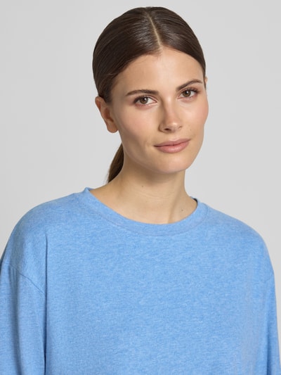 Vrouwenmodel draagt Longsleeve met geribde ronde hals van American Vintage, katoen-modal-mix met stretch, losse fit, blauwe stof, close-up bovenlichaam.