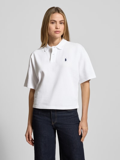 Kobiece modelka nosi Boxy Fit Koszulkę polo z wyhaftowanym logo od Polo Ralph Lauren, bawełna, kołnierzyk polo, listwa guzikowa, pudełkowy krój, długość tyłu 52 cm dla rozmiaru S, kolor biały, faktura gładka, widok całej sylwetki z przodu.