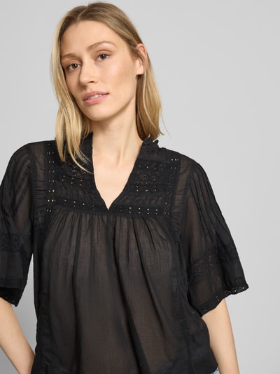 Frauenmodel trägt Blusenshirt mit V-Ausschnitt Modell 'Siama' von Neo Noir in Schwarz, mit Stitchings und Regular-Fit, Nahaufnahme Oberkörper.