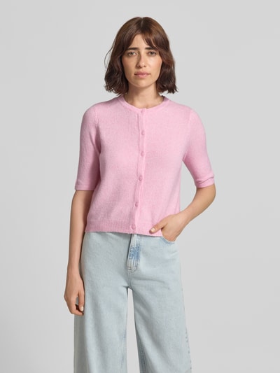 Vrouwenmodel draagt lichtroze regular fit gebreid jack met korte mouwen model 'VMDOFFY' van VERO MODA, dames, frontale opname bovenlichaam.
