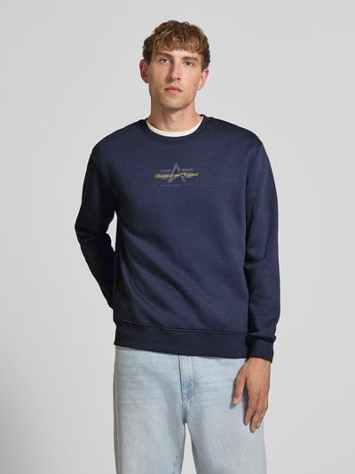 Männermodel trägt Regular Fit Sweatshirt aus Baumwoll-Mix mit Label-Detail von Alpha Industries, dunkelblau, Ganzkörperansicht von vorne