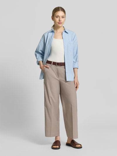 Frauenmodel trägt Stoffhose mit Eingrifftaschen Modell 'CARA' von Cambio in Beige, Wide Leg Fit, Bügelfalte, Ganzkörperansicht von vorne