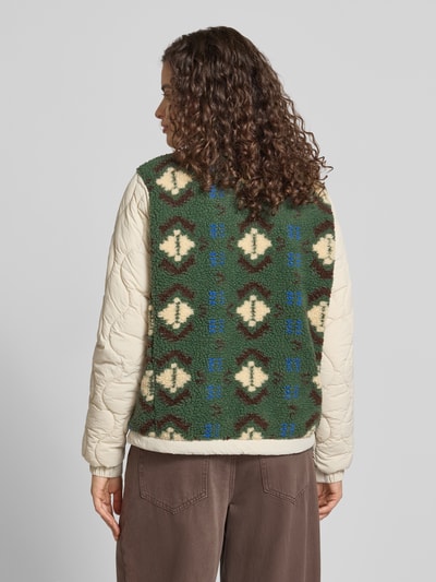 Frauenmodel trägt Fleecejacke mit Steppnähten und Label-Detail von Superdry in Grün, Beige und Braun, Strukturmix, Ganzkörperansicht Rückansicht, Damen Regular Fit, Stehkragen, Reißverschluss, Brusttasche, Rückenlänge 58 cm, Schulterbreite 39 cm, Brustweite 52 cm, Ärmellänge 65 cm.
