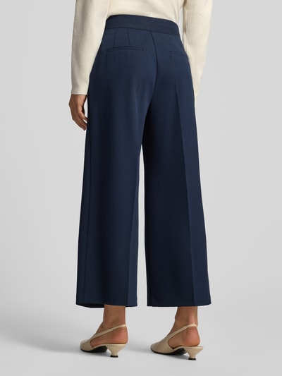 Frauenmodel trägt Culotte mit Bügelfalten von Betty Barclay in Dunkelblau, unifarben, mit seitlichen Eingrifftaschen, 7/8-Länge, Ganzkörperansicht Rückansicht.