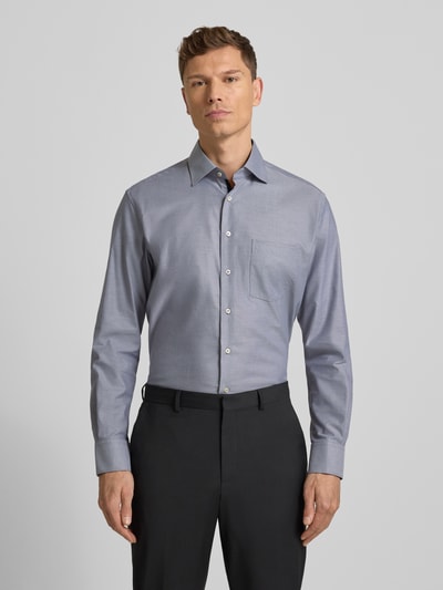 Männermodel trägt Regular Fit Businesshemd aus Baumwolle mit Kentkragen von Eterna, Knopfleiste, Brusttasche, Ganzkörperansicht von vorne. Rückenlänge 80 cm, Schulterbreite 49 cm, Ärmellänge 65 cm bei Größe 40.