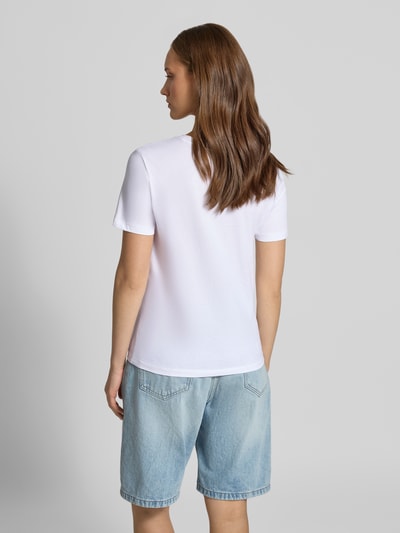 Frauenmodel trägt Regular Fit T-Shirt aus reiner Baumwolle Modell 'KITA' von ONLY in Weiß zu hellblauer Jeansshorts, Ganzkörperansicht Rückansicht, Damen T-Shirt von ONLY.