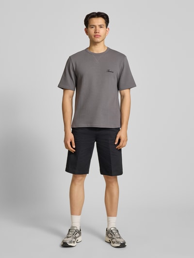 Männermodel trägt T-Shirt mit Label-Stitching von REVIEW aus Baumwoll-Mix, Waffelstruktur, gerader Schnitt, Rundhalsausschnitt, Ganzkörperansicht von vorne.