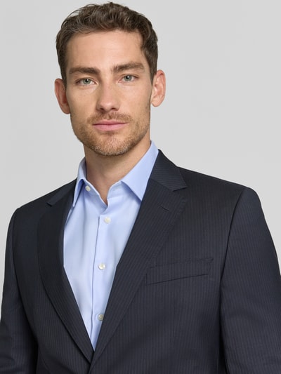 Männermodel trägt Slim Fit Anzugsakko aus reiner Schurwolle Modell 'H-HUGE-263' von BOSS, Optik:Allover-Muster, Nadelstreifen-Muster, Nahaufnahme Oberkörper.