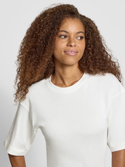 Kobiece modelka nosi damski t-shirt z bawełny, prosty krój, okrągły dekolt, model 'MALLE' od Topshop, marszczenia z wiązaniem, długość tyłu w rozmiarze S: 66 cm, ujęcie z przodu, zbliżenie na górę ciała.