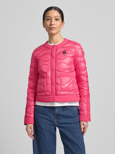 Modelka nosi różową Steppjacke mit Label-Detail Modell 'HADLEY' von Blauer Usa, krój slim fit, okrągły dekolt, zapięcie na guziki, kieszenie boczne, detal z logo, długość pleców w rozmiarze S: 49 cm, szerokość ramion w rozmiarze S: 40 cm, szerokość klatki piersiowej w rozmiarze S: 47 cm, długość rękawa w rozmiarze S: 62 cm, widok całej sylwetki z przodu.