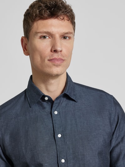 Männermodel trägt Slim Fit Freizeithemd aus Leinen-Mix von Jake*s, Dunkelblau, Kentkragen, Knopfleiste, Nahaufnahme Oberkörper.